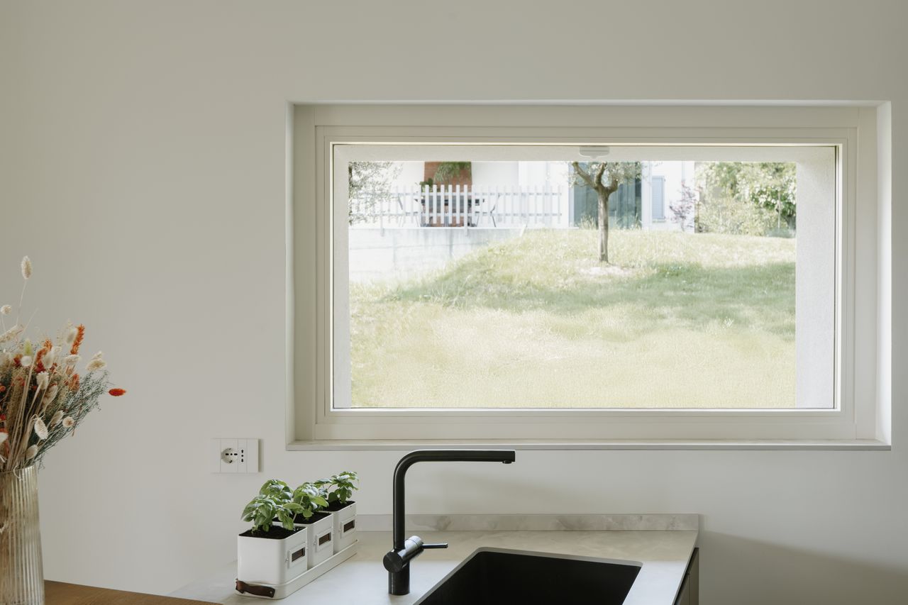 Finestra in legno QRLEGNO Natura 68 laccata bianca, installata sopra un piano cucina